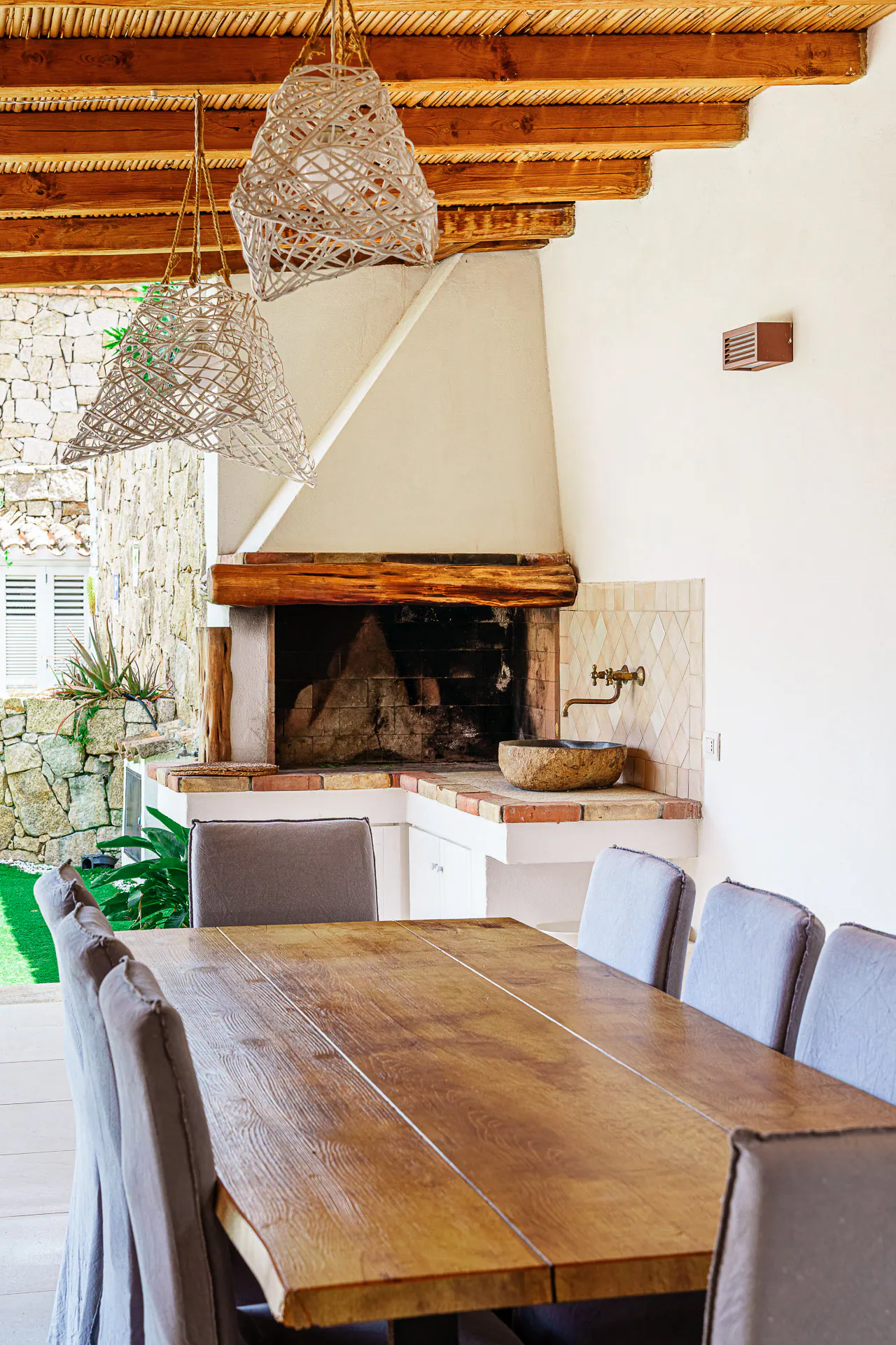 The fireplace and the wooden table on the patio