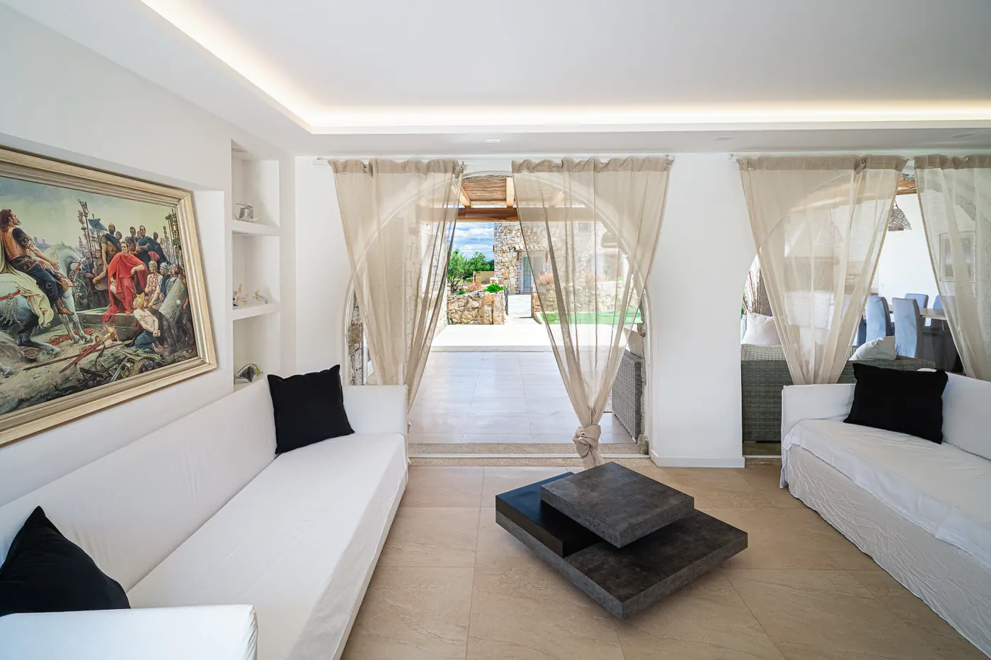 The living room with the white sofa and light curtains