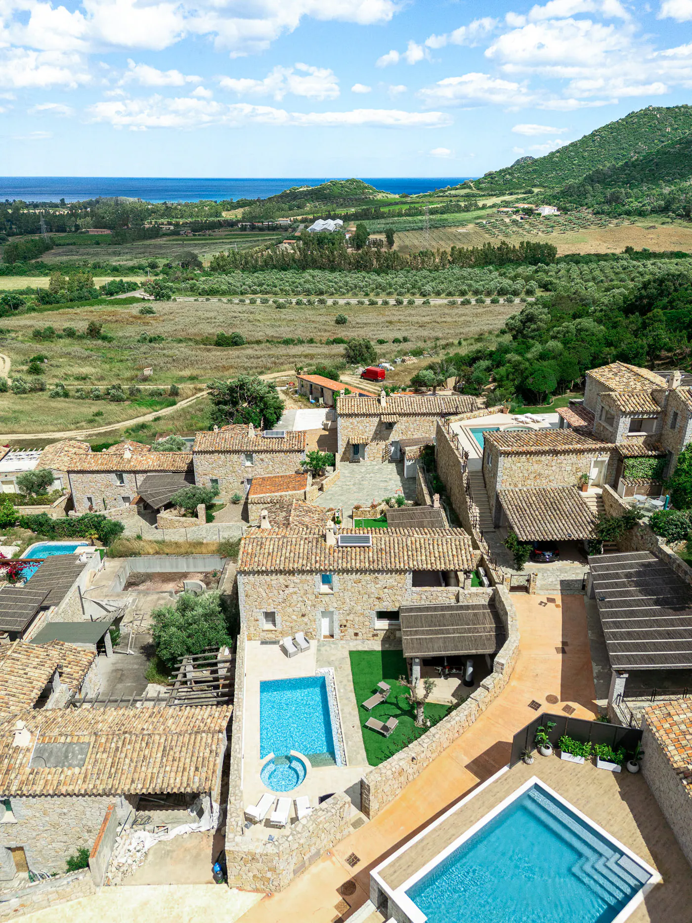 From above, the villa among the olive trees and the sea on the horizon